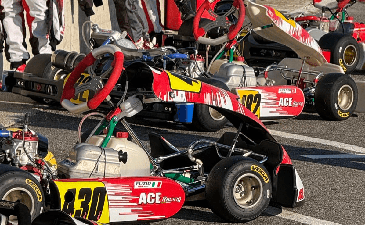 Team kart con kart, caschi e abbigliamento in livrea coordinata nel paddock